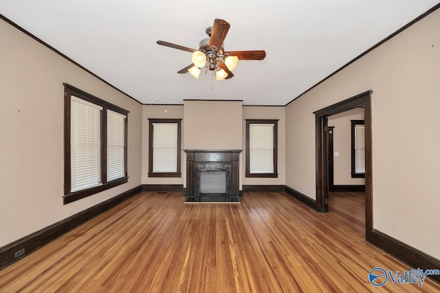 unfurnished living room featuring a wealth of natural light, hardwood / wood-style flooring, ceiling fan, and ornamental molding