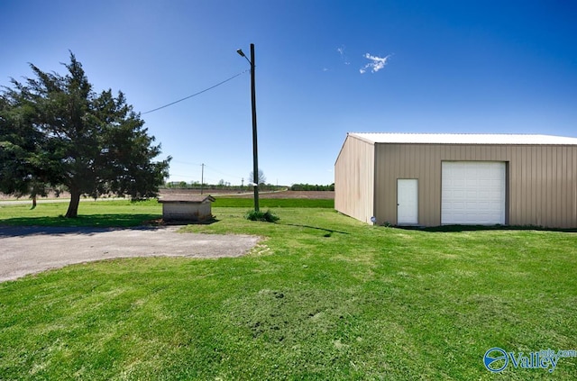 view of yard featuring a garage and an outbuilding