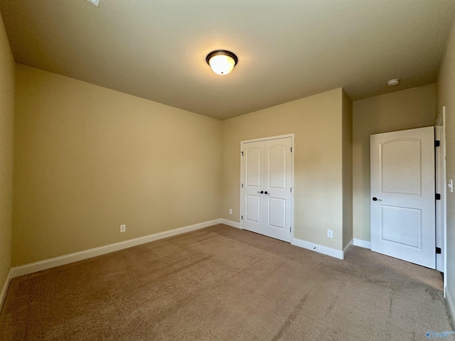 unfurnished bedroom featuring a closet and light colored carpet