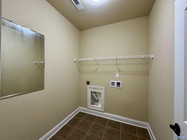 laundry area featuring electric dryer hookup, hookup for a washing machine, and dark tile patterned flooring