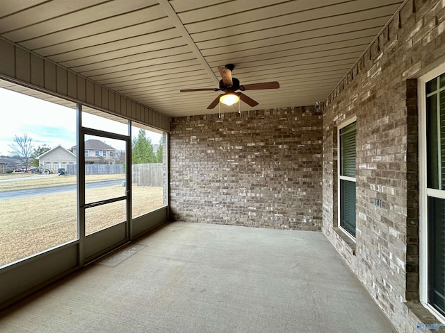 unfurnished sunroom with ceiling fan