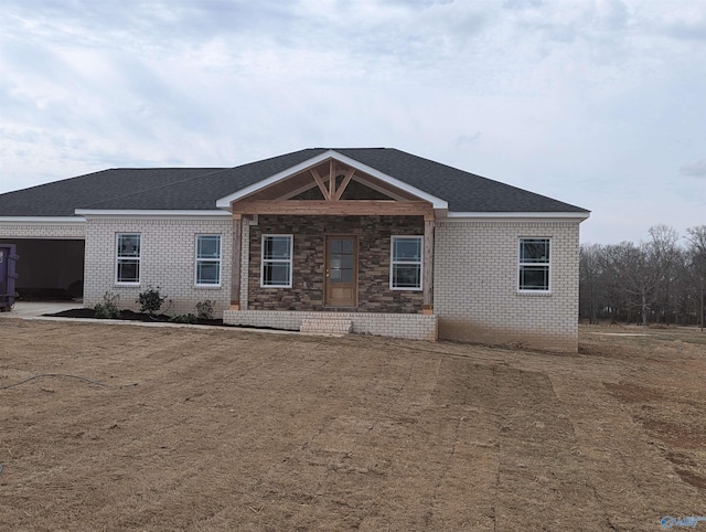 ranch-style home with brick siding and roof with shingles