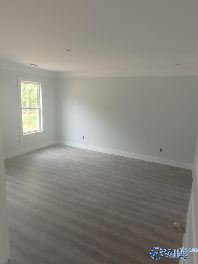 unfurnished room with baseboards and wood finished floors