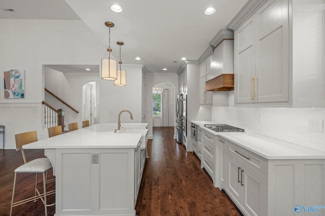 51 Summerlyn Way SE, Gurley, AL 35748 - kitchen featuring custom range hood, arched walkways, stainless steel gas stovetop, a breakfast bar, and decorative backsplash