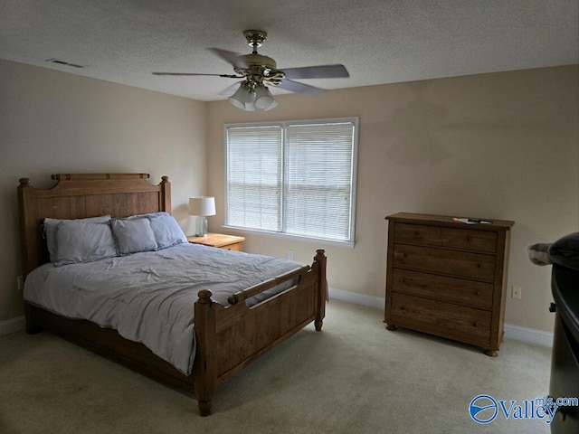 bedroom featuring light carpet, a textured ceiling, and ceiling fan