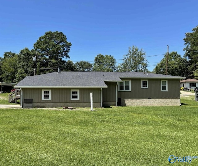 rear view of property featuring a lawn