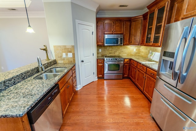 kitchen with stainless steel appliances, tasteful backsplash, hanging light fixtures, crown molding, and sink