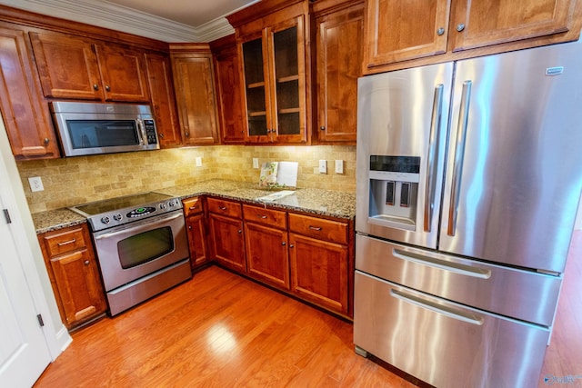 kitchen with tasteful backsplash, light stone countertops, and stainless steel appliances