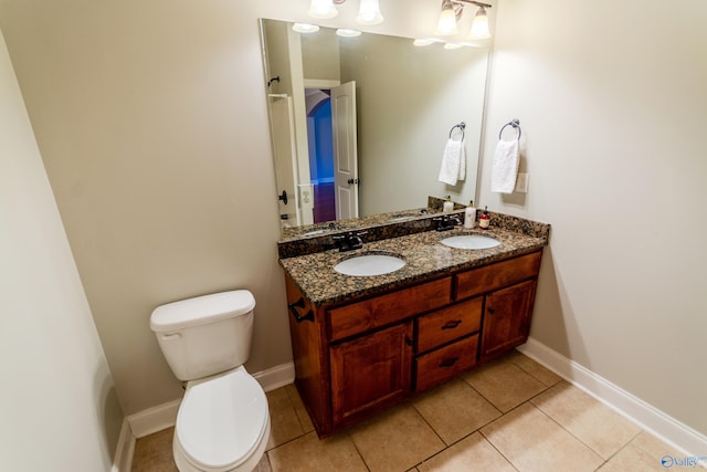 bathroom featuring toilet, tile patterned flooring, and vanity