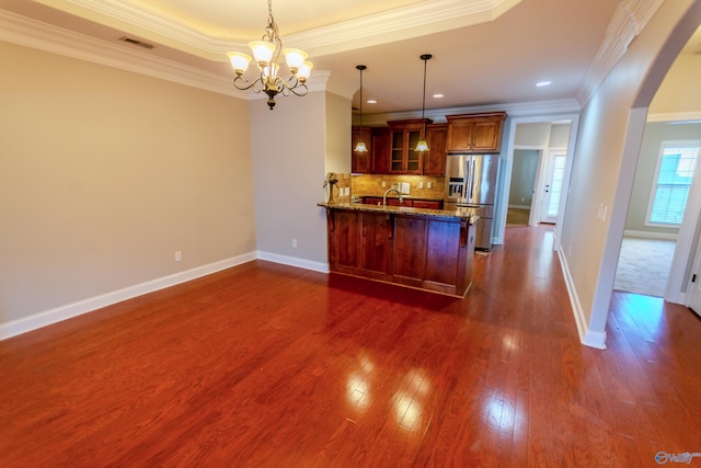 kitchen featuring decorative light fixtures, stainless steel refrigerator with ice dispenser, backsplash, and ornamental molding