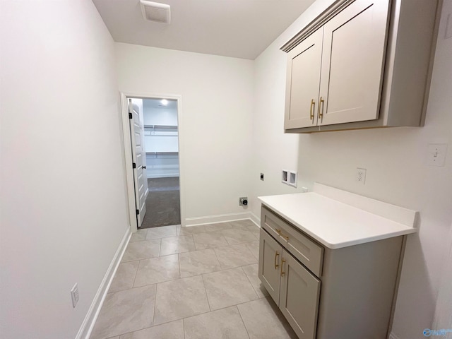 clothes washing area with cabinets, electric dryer hookup, and washer hookup