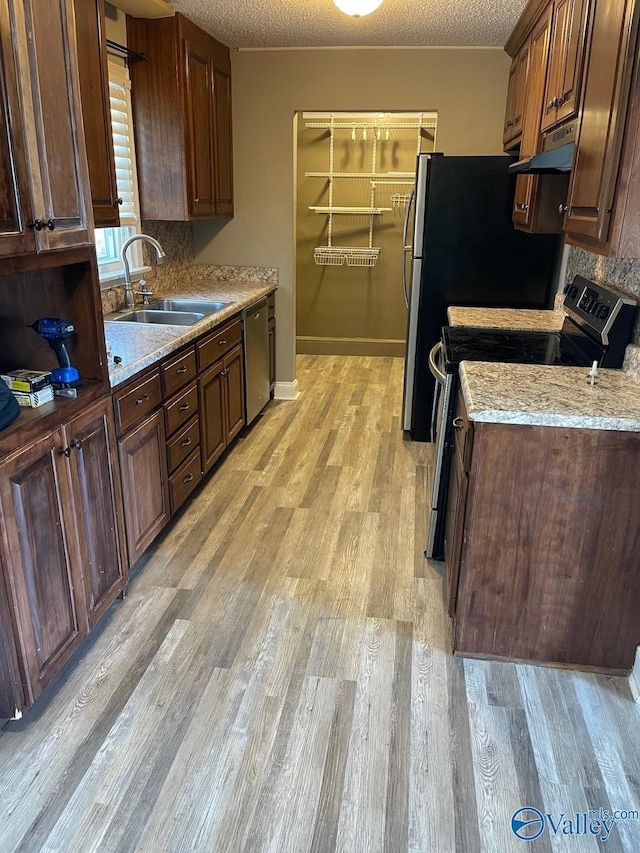 kitchen featuring dishwasher, sink, a textured ceiling, and black / electric stove