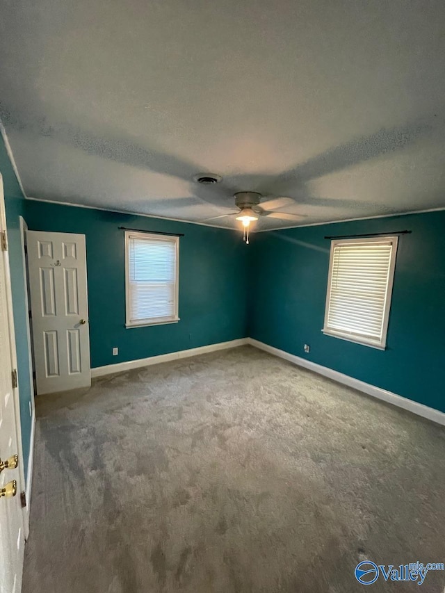 carpeted spare room with a textured ceiling and ceiling fan