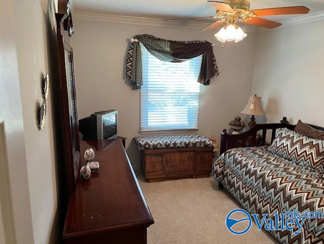 bedroom with ceiling fan, crown molding, and light colored carpet