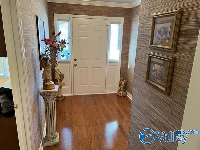 foyer with hardwood / wood-style flooring and crown molding