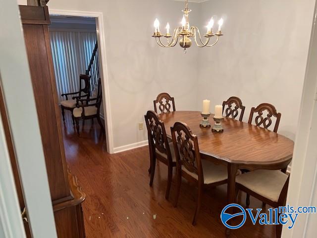 dining room featuring dark wood-type flooring and a notable chandelier