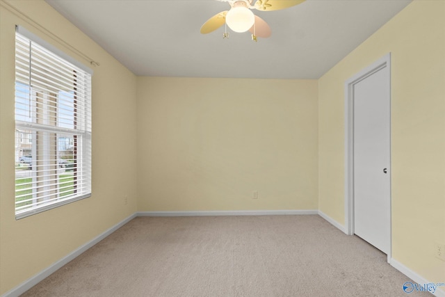 empty room featuring ceiling fan and light carpet