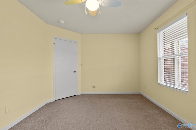 carpeted empty room featuring ceiling fan