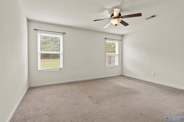 carpeted spare room with ceiling fan and a healthy amount of sunlight