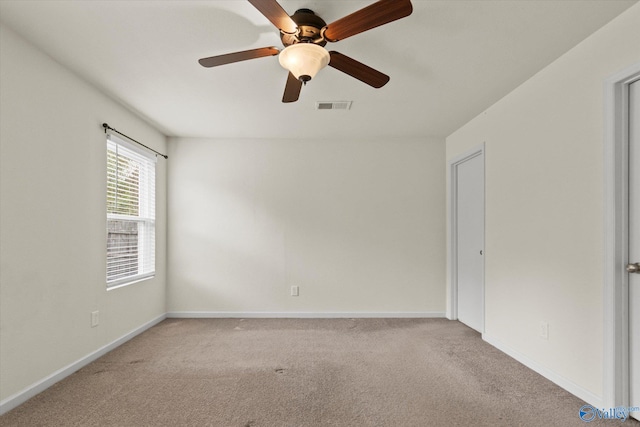 empty room with ceiling fan and light carpet