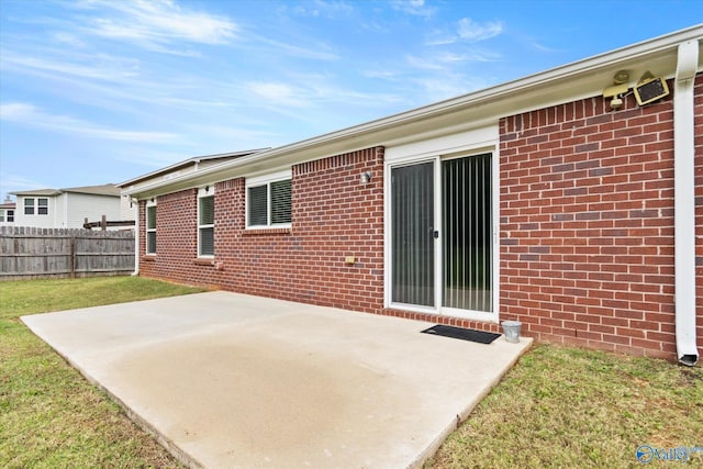 rear view of house with a patio and a lawn