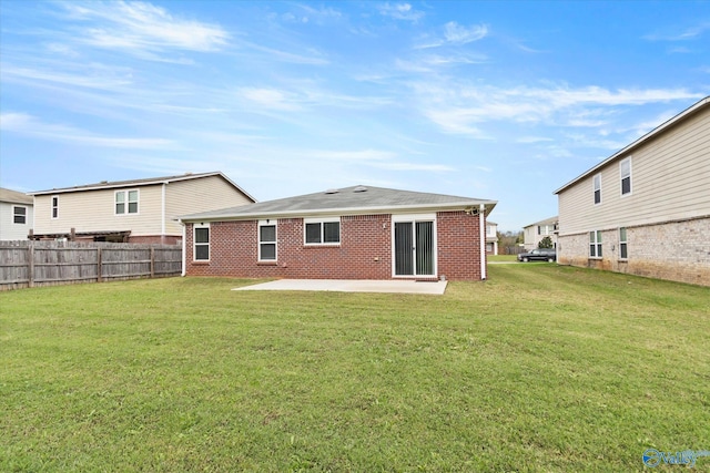 rear view of property featuring a yard and a patio