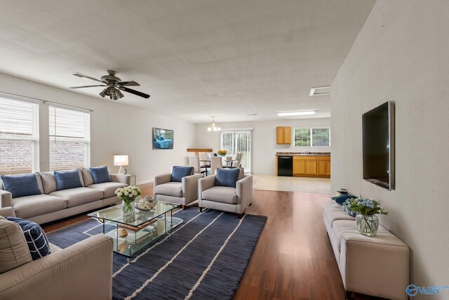 living room featuring plenty of natural light, dark hardwood / wood-style flooring, and ceiling fan with notable chandelier