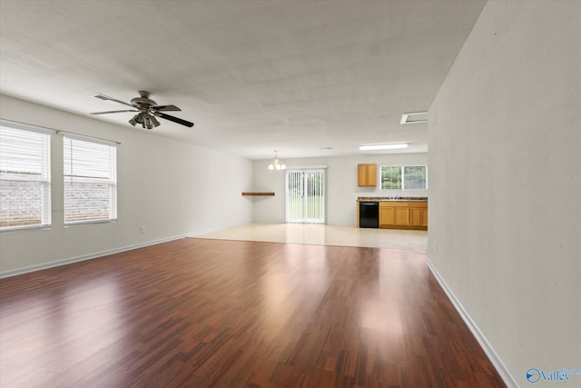 unfurnished living room featuring ceiling fan with notable chandelier and hardwood / wood-style flooring