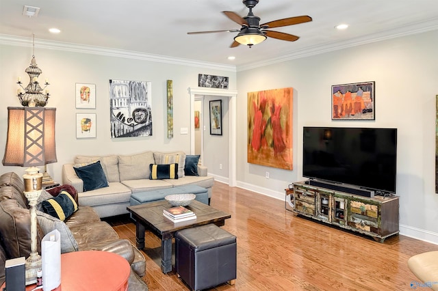 living room with hardwood / wood-style flooring, ceiling fan, and crown molding