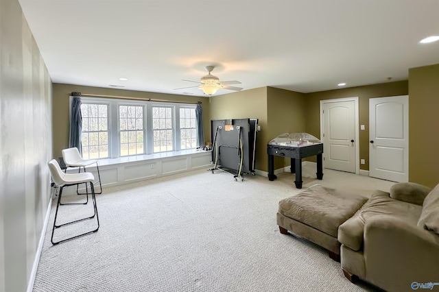 living area featuring ceiling fan and light colored carpet