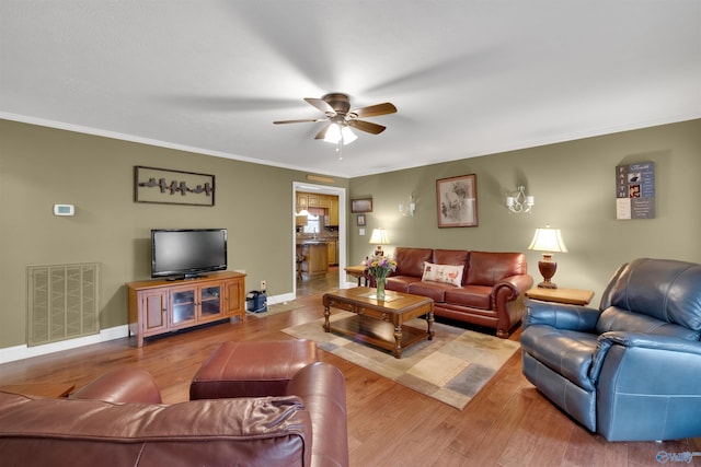 living area featuring ornamental molding, visible vents, and wood finished floors