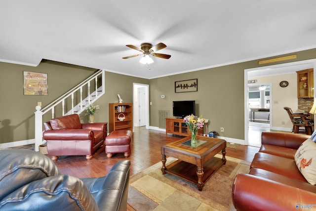 living area featuring wood finished floors, visible vents, baseboards, stairway, and crown molding