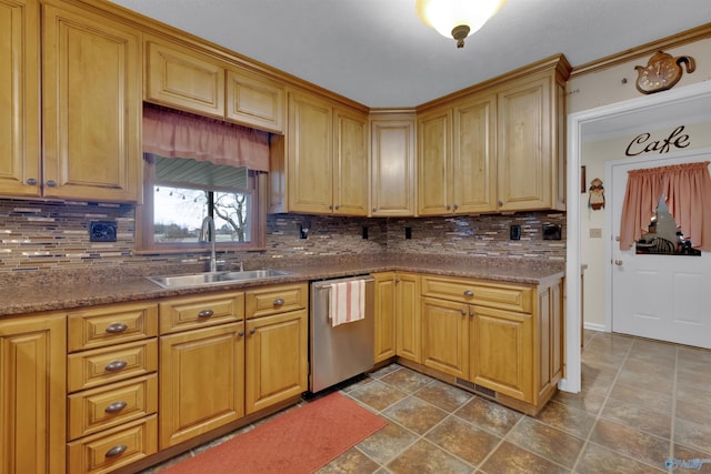 kitchen with a sink, dark countertops, tasteful backsplash, and stainless steel dishwasher