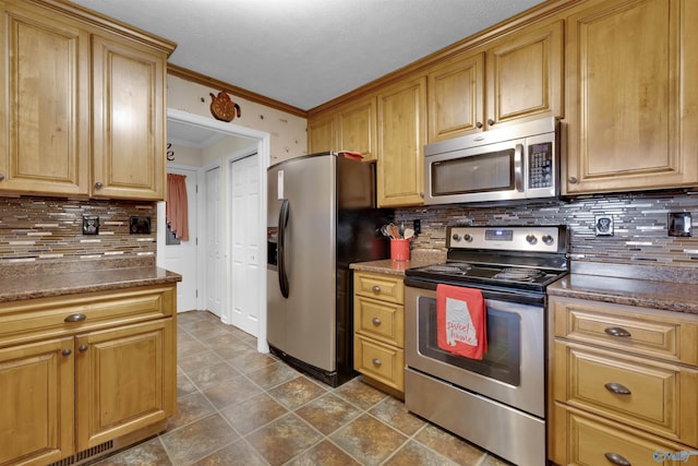 kitchen with stainless steel appliances, ornamental molding, dark countertops, and tasteful backsplash