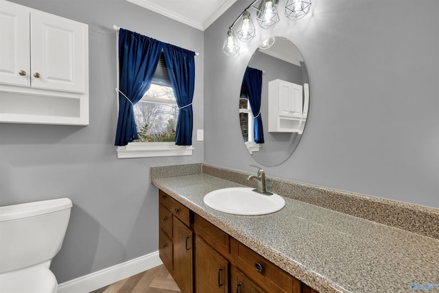 half bathroom featuring toilet, baseboards, ornamental molding, and vanity