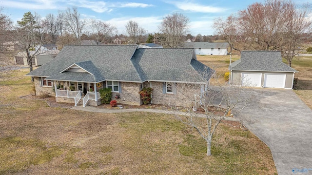 view of front of house with roof with shingles, a porch, a garage, an outdoor structure, and a front lawn