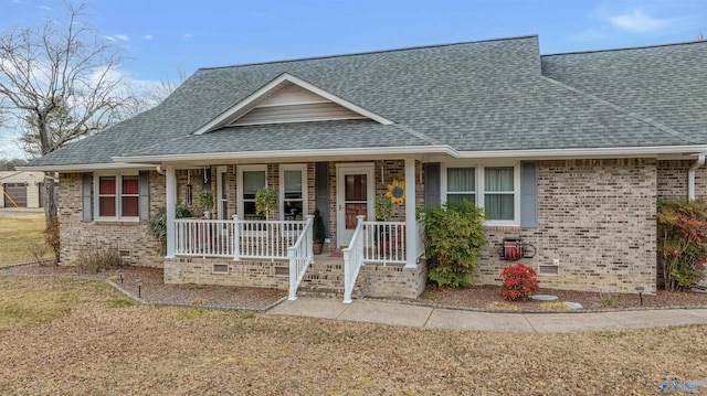 view of front of property with a shingled roof, crawl space, brick siding, and covered porch