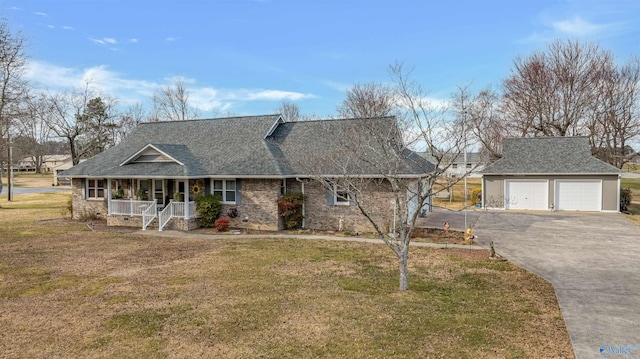 view of front of house featuring a garage, covered porch, roof with shingles, and a front lawn