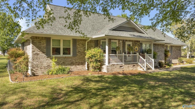 view of front of house featuring a shingled roof, a front lawn, covered porch, and brick siding
