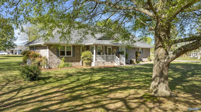 ranch-style house featuring a front lawn, brick siding, roof with shingles, and covered porch