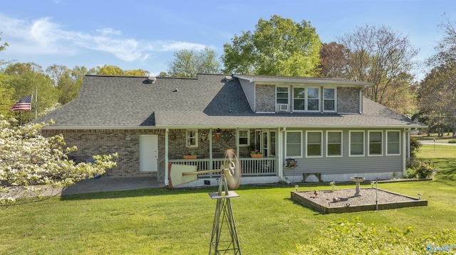 rear view of house featuring roof with shingles, a yard, a patio, and covered porch