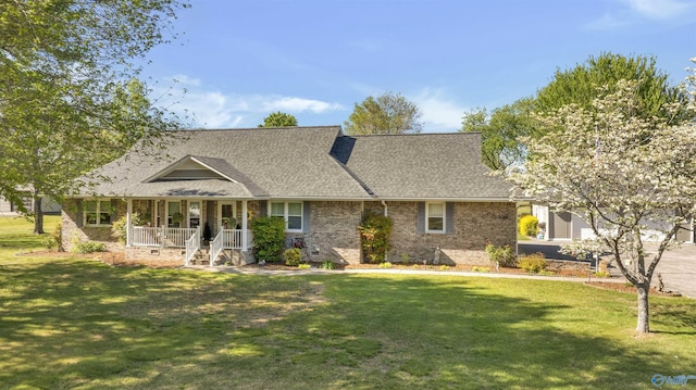 view of front of home with brick siding, a front lawn, roof with shingles, and a porch