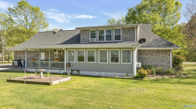 back of property featuring a shingled roof, a ceiling fan, and a yard
