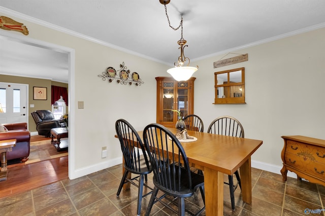 dining room featuring baseboards and crown molding