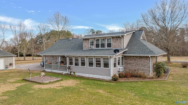 rear view of property with a yard, brick siding, a shingled roof, and cooling unit