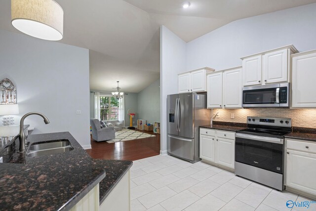 6807 Breyerton Way SE, Owens Cross Roads, AL 35763 - kitchen with stainless steel appliances, a sink, lofted ceiling, backsplash, and white cabinetry