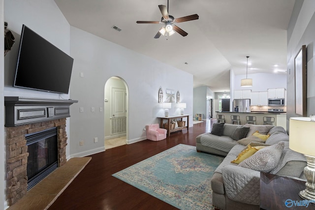 6807 Breyerton Way SE, Owens Cross Roads, AL 35763 - living area with vaulted ceiling, ceiling fan, a fireplace, arched walkways, and wood finished floors