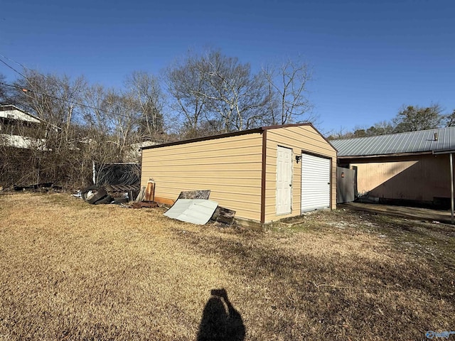 view of outdoor structure featuring a garage and a yard