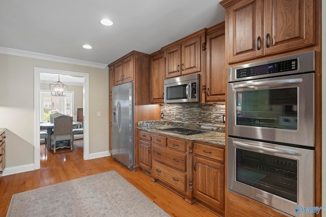 406 Zandale Dr SW, Huntsville, AL 35801 - kitchen with stainless steel appliances, brown cabinets, light wood-style floors, decorative backsplash, and recessed lighting