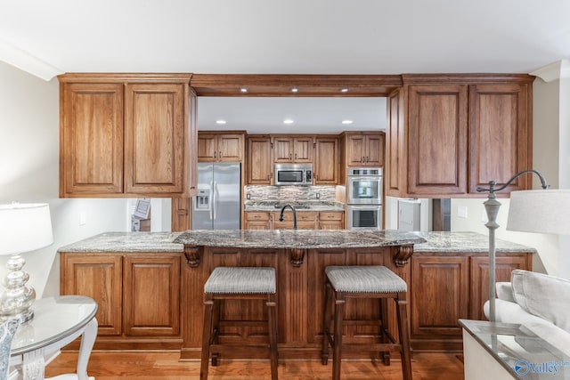 406 Zandale Dr SW, Huntsville, AL 35801 - kitchen with appliances with stainless steel finishes, a peninsula, light stone countertops, and recessed lighting